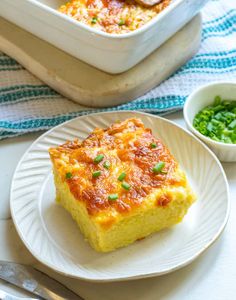 a white plate topped with a piece of quiche next to a bowl of peas