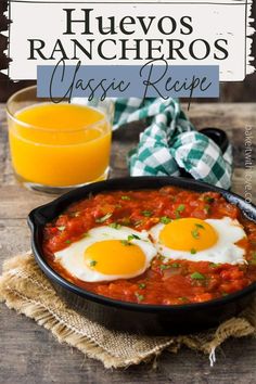 two eggs are in a skillet with tomato sauce on the side, and an orange juice