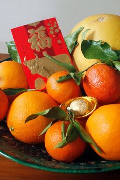 oranges and tangerines in a bowl on a table with a red card