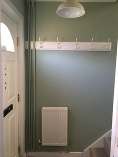 an empty room with a radiator on the wall and a light fixture above it