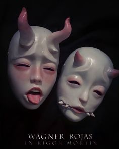 two white masks with horns and fangs on their faces are shown in front of a black background