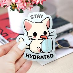 a sticker that says stay hydrated with a cartoon cat holding a glass in it's hand