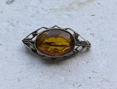 I collect and recreate art nouveau and art deco jewelry designs using authentic vintage glass beads from high-end estate sales and a mix of vintage and new findings to create unique, one-of-a-kind pieces. This is not a recreation - it's a cute, dainty art nouveau topaz brooch.  I have been designing and collecting jewelry for more than 10 years as an investment in the future. I recently battled leukemia and I am in remission now (hooray and have decided to start my dream business with authentic Vintage Gemstone Brooches For Formal Occasions, Art Nouveau Filigree Brooch For Collectors, Collectible Art Nouveau Filigree Brooches, Art Deco Oval Brooch Jewelry, Oval Art Deco Brooch For Formal Occasions, Oval Art Deco Brooches For Formal Occasions, Art Deco Oval Brooch, Art Deco Formal Oval Brooches, Art Deco Cabochon Brooches Collectible