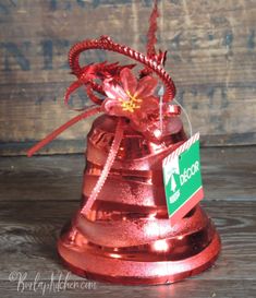 a red metal bell with a flower on it