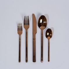 five forks, two spoons and one knife on a white surface