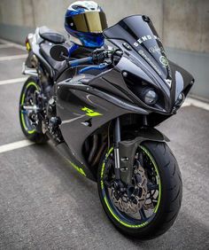 a black motorcycle parked in a parking lot next to a building with graffiti on it