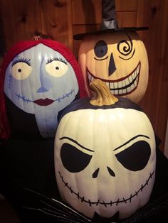 three pumpkins with faces painted on them