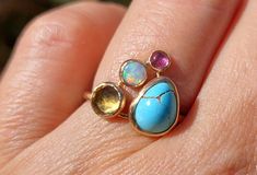 This one is great! The main stone is a lovely teardrop Turquoise with veins (measures about 9 X 7 mm) and on the side, I set a 5 mm faceted Citrine, a 4 mm white Opal and a 3 mm pink Tourmaline. The band is round. 1.5 mm wide. All the ring and settings are made of 14k solid gold. Comfortable, stackable and very colorful! READY TO SHIP! in a size 6.5 and can be enlarged a bit up to a 7 (or so). Ships in a gift box. Please contact me with any questions or requests : ) Turquoise Birthstone Ring, Turquoise Birthstone, Hodge Podge, Ring Ideas, Citrine Ring, Turquoise Rings, Lovely Ring, Multi Stone Ring, White Opal