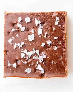 a square piece of chocolate cake with coconut flakes on top