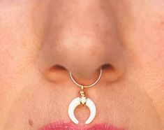 a woman's nose with a ring around it and a crescent on the lip