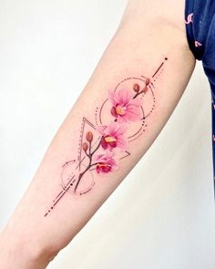 a woman's arm with pink flowers and geometric shapes on the left inner arm