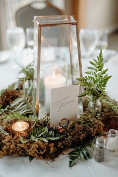 a table with candles and greenery on it