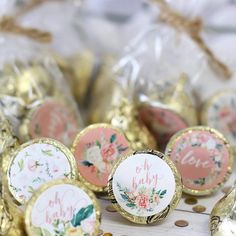 some candy wrapped in gold foil with floral designs on them and the words oh baby printed on it