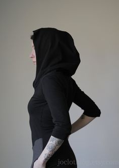 "Hooded tunic dress with patch pockets. Half sleeves. Soft, black cotton spandex jersey with black and charcoal grey waffle sweater knit details. Large, cowl style hood. Length from shoulder to hem 32-33\". See size chart below. Handmade to order. Please check the shop announcement for my current turnaround time- http://www.etsy.com/shop/joclothing?ref=si_shop Available in sizes X-Small, Small, Medium, Large, X-Large, XX-Large. (please indicate the size you would like or provide your measurement Fitted Cotton Techwear Hoodie, Black Winter Outerwear With Thumbholes, Casual Black Outerwear With Thumbholes, Black Fitted Techwear Hoodie, Fitted Black Cotton Hoodie, Black Fitted Cotton Hoodie, Fitted Winter Hoodie With Thumbholes, Fitted Hoodie With Thumbholes, Dress With Sweater