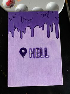 a purple piece of paper with the word hell painted on it