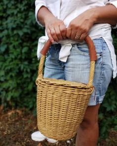 a woman holding a wicker basket in her hands