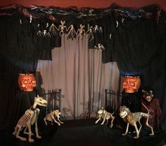 halloween decorations in the shape of skeletons and pumpkins are displayed on black stage curtains