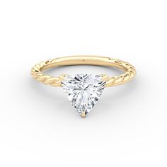 a yellow gold engagement ring with a pear shaped diamond in the center and braided band