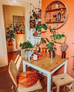 a table with some plants on top of it and two stools next to it