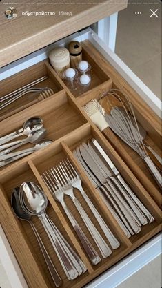 an open drawer filled with silverware and utensils on top of a counter