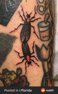 a close up of a person's arm with tattoos on it and an insect