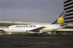 an american airlines plane is parked in front of the terminal building at an airport on a cloudy day