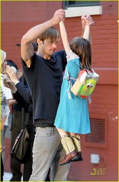 a young man and woman dancing together on the street