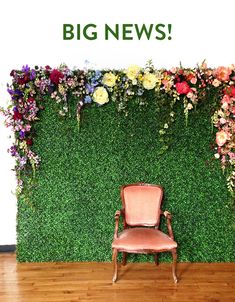 a chair sitting in front of a green wall with flowers on it and a wooden floor