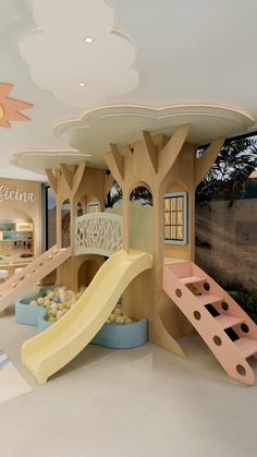 the inside of a children's play area with slide and climbing equipment in it