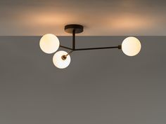 three globes are hanging from the ceiling in this modern style light fixture, which is black and white