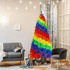 a colorful christmas tree in the middle of a living room next to a gray couch