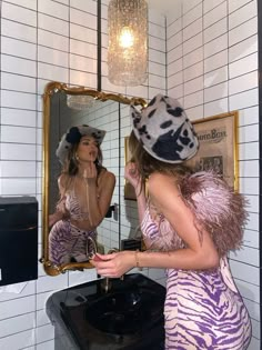 a woman in a zebra print dress is brushing her teeth while looking at herself in the mirror