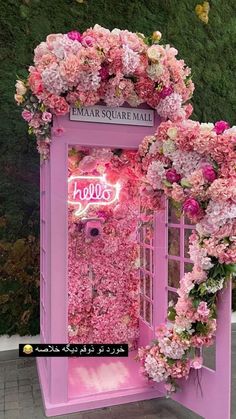 a pink phone booth decorated with flowers