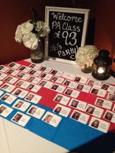 a table topped with pictures and flowers next to a sign that says welcome pa class of'69