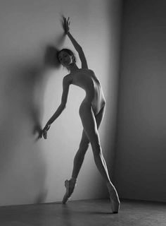 black and white photograph of a ballerina leaning against a wall