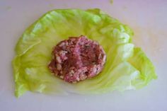 lettuce with meatballs in the middle on a white counter top, ready to be cooked