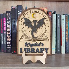 a wooden sign that reads, i'm my fantasy library with a dragon on it