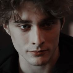 a close up of a person wearing a jacket and looking at the camera with an intense look on his face