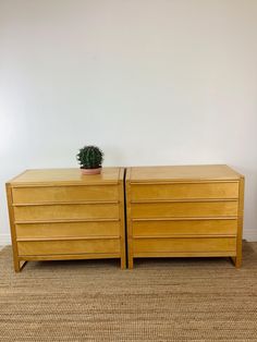 two wooden dressers sitting next to each other on carpeted floor in front of white wall