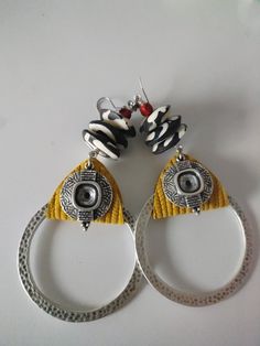 These funky afrocentric hoop earrings are a statement in themselves! Textured warm yellow leather is the backdrop to a batik bone beaded neck. These earrings are accented with a small brick red etched bone bead.  The base is a textured hammered silver circle.  Rock these earrings with ease to all of your holiday outings and effortlessly with all of your summer dresses! Diy Soda, Boho Yellow, Afrocentric Jewelry, Bead Earring, Earrings Aesthetic, Warm Yellow, Earring Ideas, Silver Circle, Bone Beads