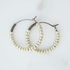 These hypoallergenic 1-inch beaded hoop earrings are handmade using pure grade 1 titanium and silver Czech glass beads. A titanium coil accents each hoop and keeps the beads neatly in place. The smooth, polished wires are easy to insert and fasten securely into looped ends. Perfect everyday earrings and comfortable to wear while sleeping.  Handmade with love in North Carolina. ABOUT TITANIUM: Titanium is a strong, lightweight metal that has a beautiful gunmetal silver tone. It does not discolor Glass Bead Jewelry, Earrings For Sensitive Ears, Glass Beads Jewelry, Beaded Hoop Earrings, Beaded Hoops, Bead Jewelry, Everyday Earrings, Handmade Boho, Sensitive Ears