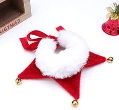 a red and white christmas ornament sitting on top of a table next to other decorations