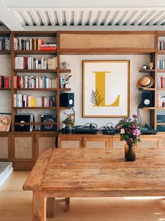 a wooden table sitting in front of a book shelf filled with books