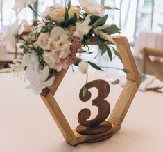 the table numbers are made out of wood and have flowers in them on each side