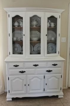 a white china cabinet with glass doors