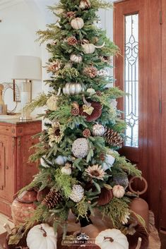 a christmas tree decorated with pine cones and pumpkins