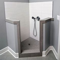 a shower stall with an open door in the middle and a tiled floor on the other side