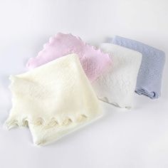 three different colors of towels on a white background