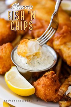 fish n chips with lemon wedges and dipping sauce on a fork in the middle