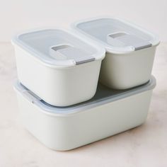 three plastic containers stacked on top of each other, with lids down and one empty